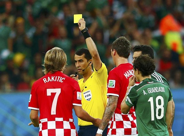 Chorvatský fotbalista Ivan Rakitič (vlevo) dostává žlutou kartu od rozhodčího Ravshana Irmatova z Uzbekistánu v utkání proti Mexiku.