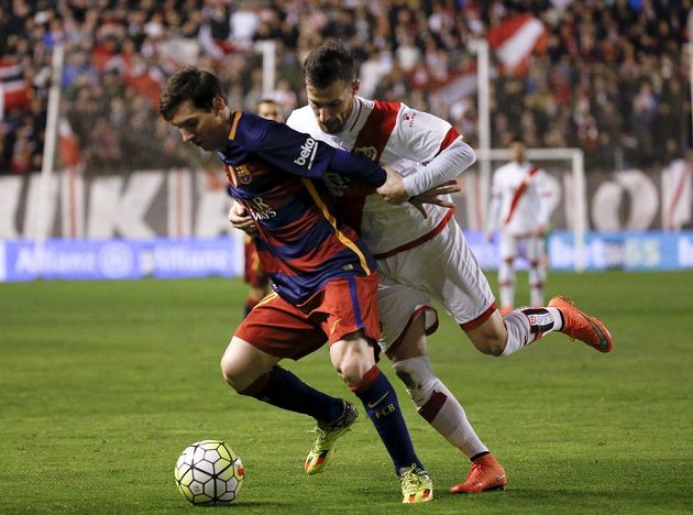 Obránce Vallecana Roberto "Tito" Roman (vpravo) se snaží zastavit Lionela Messiho z Barcelony v utkání 27. kola španělské ligy.
