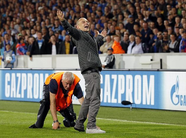 Pořadatel na stadiónu v Bruggách se snaží zastavit výtržníka, který vběhl na hrací plochu během odvety play off Ligy mistrů proti Manchesteru United.