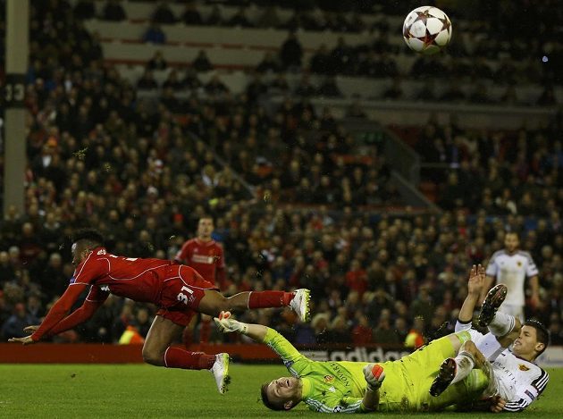 Brankář Basileje Tomáš Vaclík (na zemi) zastavuje šanci pronikajícího záložníka Liverpoolu Raheema Sterlinga (vlevo).