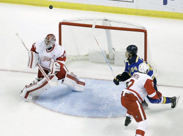 Gólman Petr Mrázek z Detroitu, jeho spoluhráč Brendan Smith (2) a Nail Jakupov (64) ze St. Louis.