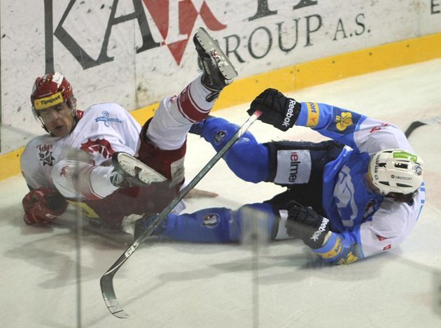 Forvard Třince Jiří Polanský (vlevo) a plzeňský Radek Duda padají po vzájemném souboji v utkání 17. kola extraligy.