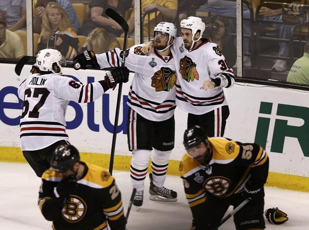 Dave Bolland (vpravo) se raduje se spoluhráči Marcusem Krugerem (uprostřed) a Michaelem Frolíkem z gólu proti Bostonu.