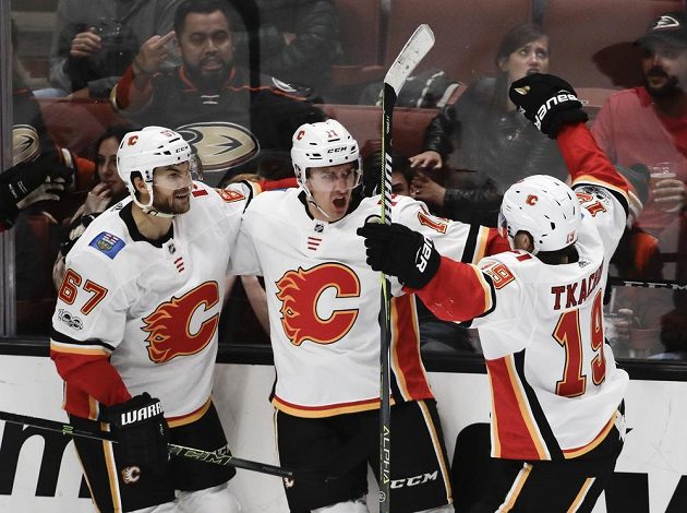 Mikael Backlund (uprostřed) z Calgary slaví gól společně s Michaelem Frolíkem (vlevo) a Matthewem Tkachukem.