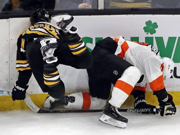 Drsná scéna. Český útočník Bostonu David Pastrňák leté hlavou vstříc mantinelu po souboji s obráncem Philadelphie Flyers Ivanem Provorovem.