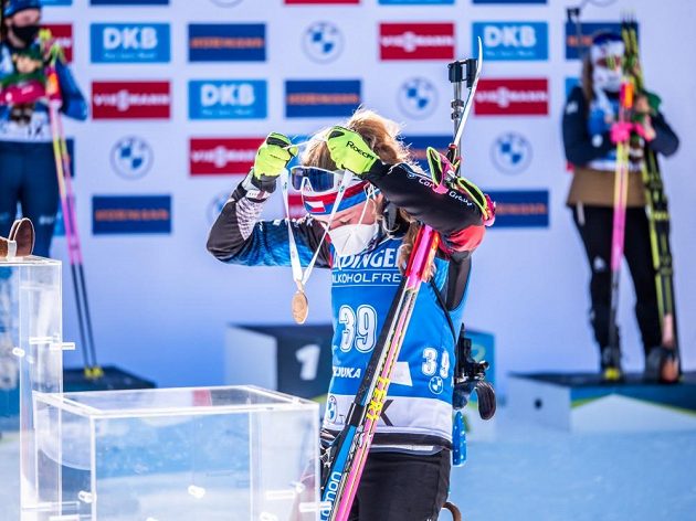 Titul v době koronavirové přináší i neobvyklou sebedekoraci. Markéta Davidová si věší v Pokljuce na krk zlatou medaili po triumfu ve vytrvalostním závodu.