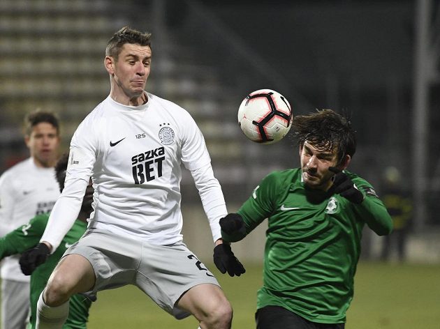 Příbramský Jaroslav Tregler se dostává k hlavičce přes sparťanského obránce Ondřeje Zahustela.