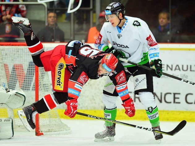 Hokejista Rudolf Červený z Hradce v akrobatické pozici po souboji s Davidem Němečkem z Mladé Boleslavi během utkání 35. kola extraligy.