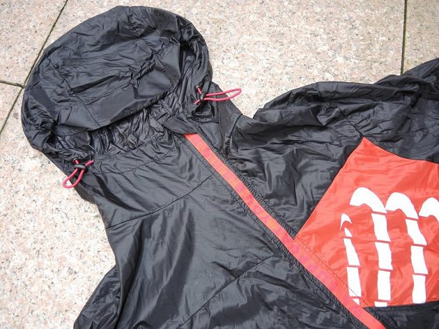 CompresSport Trail Hurricane Jacket - jedním z nejnápadnějších prvků větrovky je excentrický zip.