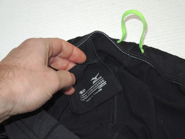 Běžecké legíny Mizuno Breath Thermo Tights: Detail malé kapsičky a šňůrky sešité do kruhu.