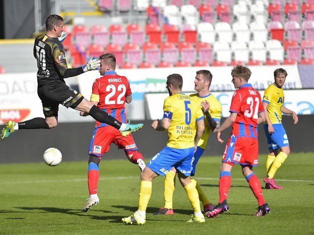 Brankář Teplic Tomáš Grigar zasahuje před plzeňským Jakubem Brabcem v pohárovém semifinále.
