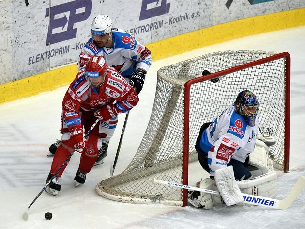 Jakub Petružálek (vlevo) z Třince u chomutovského brankáře Jána Laca, vzadu Juraj Valach.