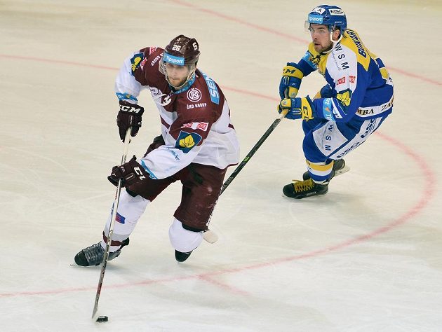 Sparťanský obránce Juraj Mikuš (vlevo) a zlínský forvard Roberts Bukarts v dohrávce 15. kola hokejové Tipsport extraligy.