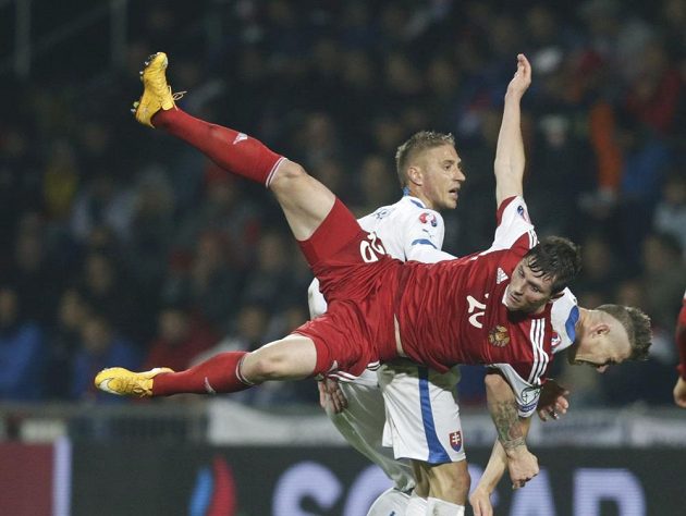 Slovák Juraj Kucka (vpravo dole) a Nikolaj Signevič z Běloruska během kvalifikačního střetnutí o postup na ME 2016.