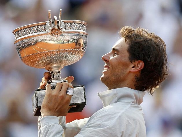 Španělský tenista Rafael Nadal se dívá na svůj odraz v poháru pro vítěze finále French Open.