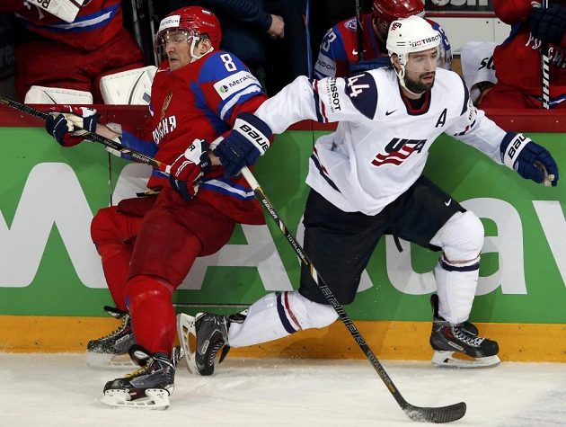 Ruský snajpr Alexandr Ovečkin (vlevo) v souboji u hrazení s Natem Thompsonem z USA.