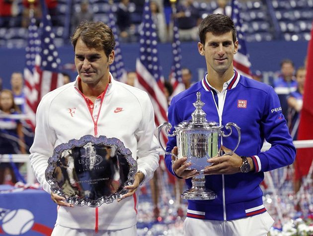 Roger Federer (vlevo) pózuje s trofejí pro poraženého finalistu US Open vedle vítězného Novaka Djokoviče.
