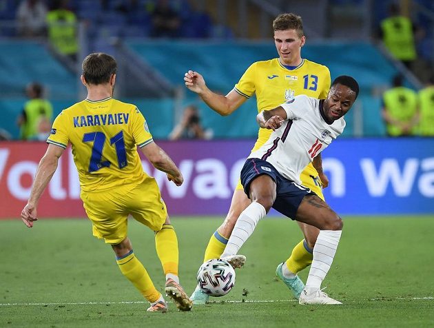 Anglický fotbaista Raheem Sterling v akci během čtvrtfinále EURO s Ukrajinou. Atakuje jej Ilja Zabarnyj.