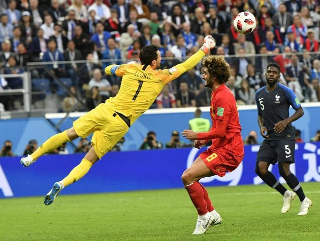 Francouzský brankář Hugo Lloris sbírá míč z hlavy Marouana Fellainiho z Belgie.