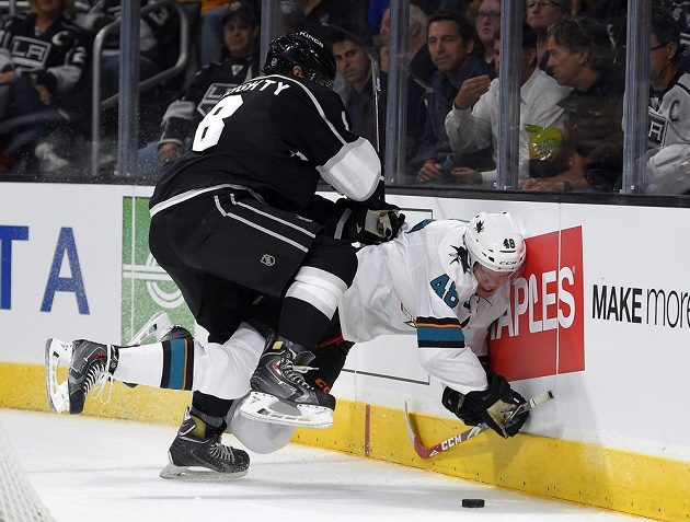 Tomáš Hertl ze San Jose trpí u mantinelu po nájezdu obránce Los Angeles Drewa Doughtyho.