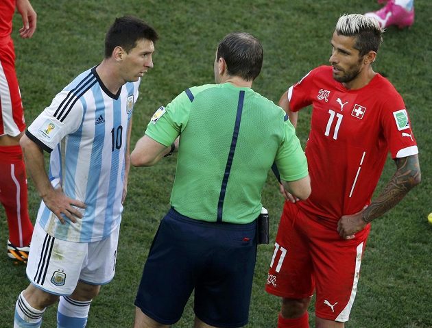 Argentinec Lionel Messi (vlevo) a Švýcar Valon Behrami (vpravo) v debatě s rozhodčím Jonasem Erikssonem.