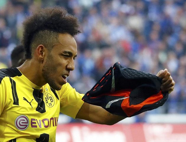 Dortmundský střelec Pierre-Emerick Aubameyang se chystá nasadit masku poté, co vstřelil gól do sítě Schalke.