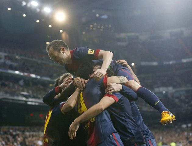 Andres Iniesta na vrcholu pyramidy hráčů Barcelony, kteří oslavují gól Cesca Fábregase proti Realu Madrid.