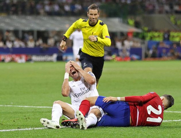 Zadák Bílého baletu Pepe (v bílém) po střetu s Yannickem Ferreirou Carrascem z Atlétika Madrid.