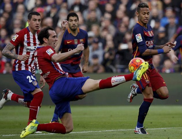 Obránce Atlétika Madrid Diego Godín odkopává míč před brazilským útočníkem Neymarem z Barcelony.