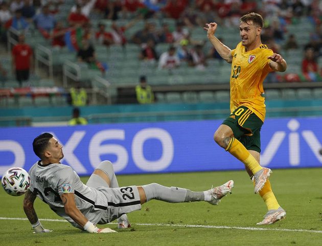 Welshman Aaron Ramsey overcomes Turkish goalkeeper Ugurcan Cakir.