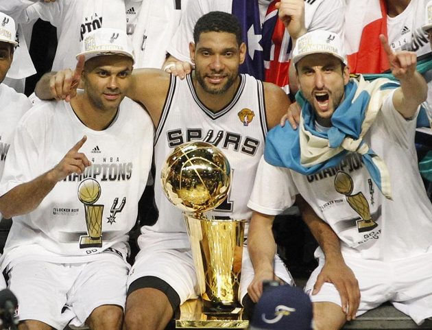Basketbalisté San Antonio Spurs (zleva) Tony Parker, Tim Duncan a Manu Ginobili pózují s trofejí Larryho O'Briena po vítězném pátém finálovém duelu NBA s Miami Heat.