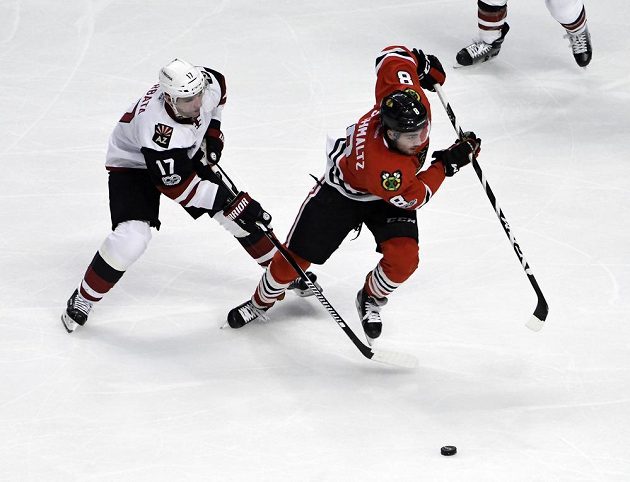 Český hokejista Arizony Coyotes Radim Vrbata (v bílém) bojuje o puk s Nickem Schmaltzem z Chicaga Blackhawks v utkání NHL
