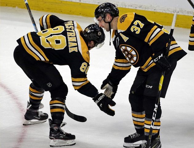Hvězdy Bostonu slaví. Útočník David Pastrňák (88) a jeho parťák z první lajny Patrice Bergeron (37) se těší z výhry 6:4 nad Calgary Flames v utkání NHL.