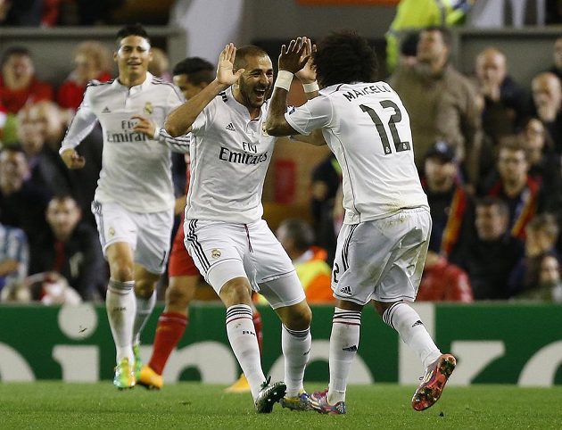 Fotbalisté Realu Madrid Karim Benzema (vlevo) a Marcelo (v pozadí James Rodrigues), slaví gól proti Liverpoolu v Lize mistrů.