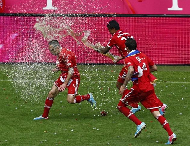 Francka Ribéryho (vlevo) polívá pivem spoluhráč z Bayernu Mnichov Luiz Gustavo (uprostřed). Vpravo přihlíží Mario Manžukič.
