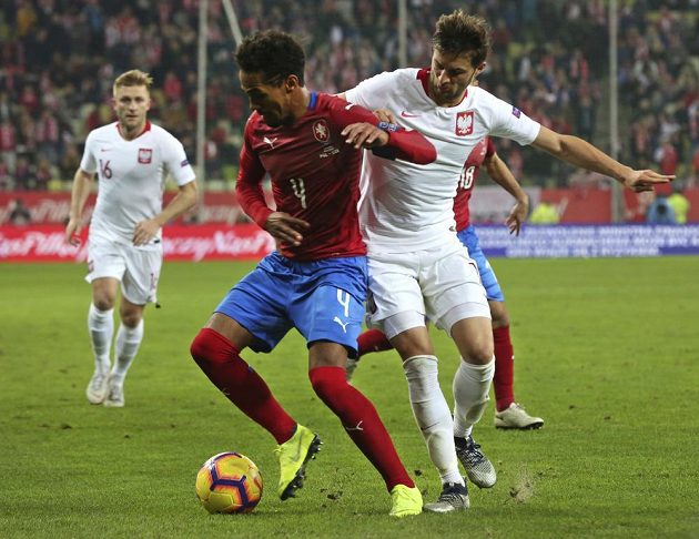 Český obránce Theodor Gebre Selassie (uprostřed) brání míč před dotírajícím Bartoszem Bereszynskim z Polska. 