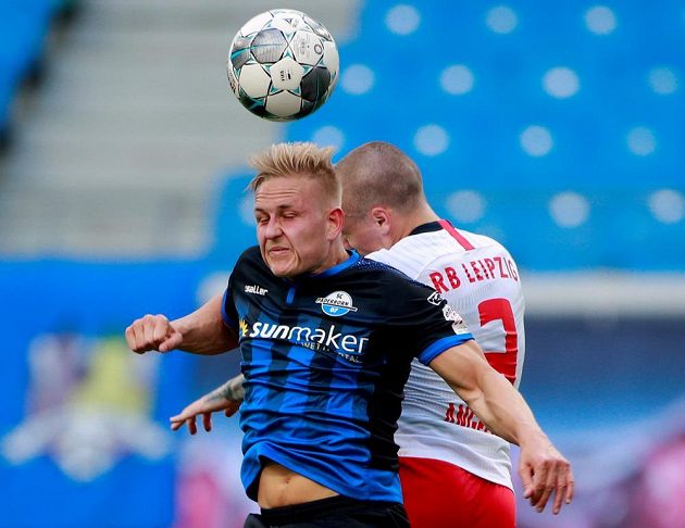 Kai Proger z Paderbornu v akci v ostrém hlavičkovém souboji s Angelinem z Lipska v bundesligovém utkání.