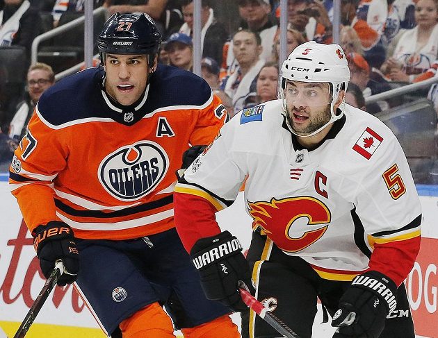Obránce Calgary Mark Giordano a útočník Edmontonu Oilers Milan Lucic během utkání NHL.