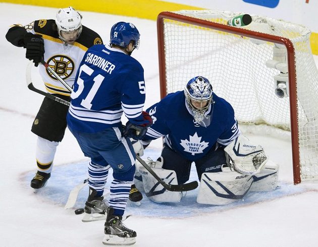 Útočník Bostonu Jaromír Jágr (vlevo) v souboji s obráncem Toronta Jakem Gardinerem. Vpravo brankář Maple Leafs James Reimer.