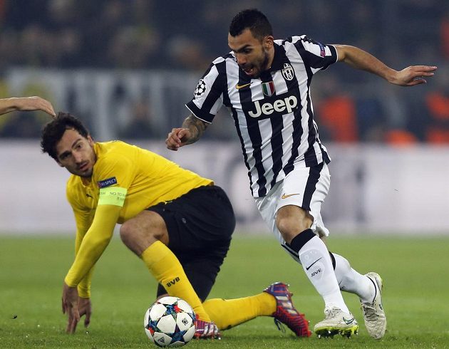 Hvězda Juventusu Turín Carlos Tévez obchází kapitána Dortmundu Mattse Hummelse.