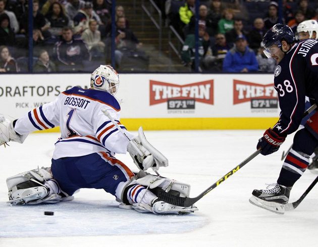 Útočník Boone Jenner (38) z Columbusu překonává brankáře Edmontonu Laurenta Brossoita (1) v zápase NHL.