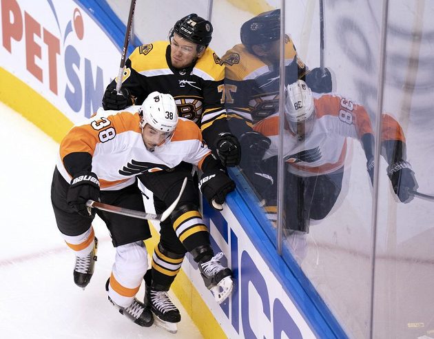 Útočník hokejové Philadelphie Flyers Derek Grant (38) čelí ataku obránce Bostonu Bruins Jeremyho Lauzona (79).