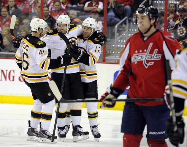 Bostonský Jarome Iginla (12) během druhé třetiny proti Washingtonu slaví gól s Davidem Krejčím (46) a Andrejem Meszarosem (41).