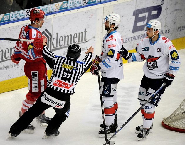 Zleva útočník Třince Marek Růžička a chomutovští obránci Brett Skinner a Jan Rutta.