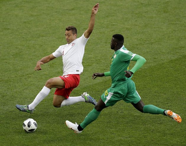 Polský fotbalový reprezentant Thiago Cionek se snaží zastavit během utkání MS Senegalce Ismaila Sarra.