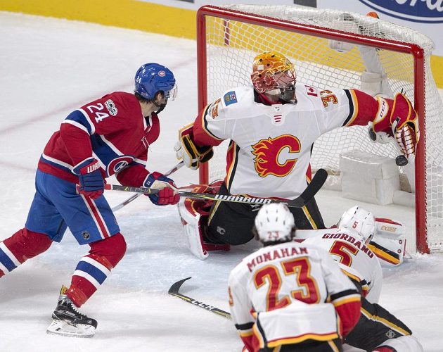 Útočník Montrealu Canadiens Phillip Danault překonává Davida Ritticha v brance Calgary v utkání NHL.