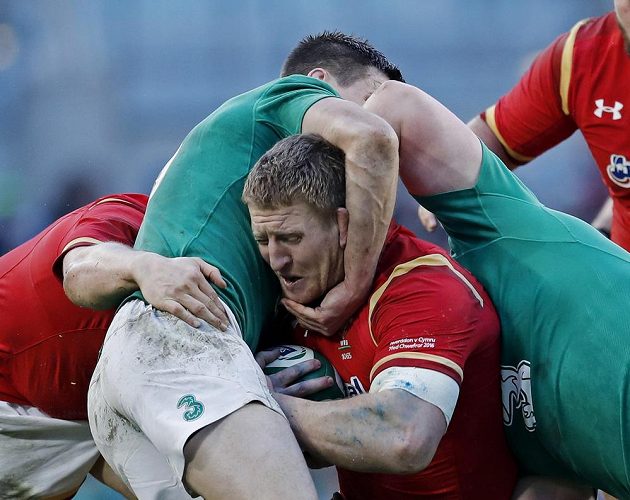 Hlava místo šišky!? Ir Jonathan Sexton rázně zastavuje Bradley Daviese z Walesu.