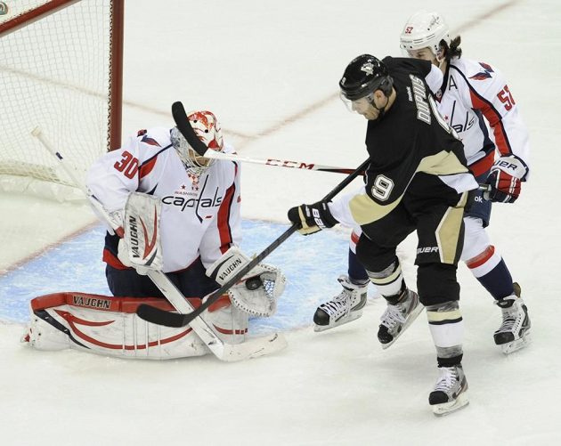 Gólman Washingtonu Michal Neuvirth schovává puk v lapačce po teči Pascala Dupuise z Pittsburghu.