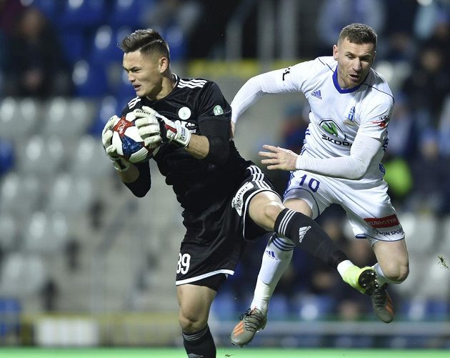 Brankář Bohemians Patrik Le Giang chytá míč před Murisem Mešanovičem z Mladé Boleslavi.