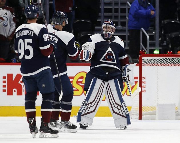 Hokejisté Colorada Avalanche André Burakovsky a Erik Johnson gratulují po vítězném utkání v NHL brankáří Pavlu Francouzovi.